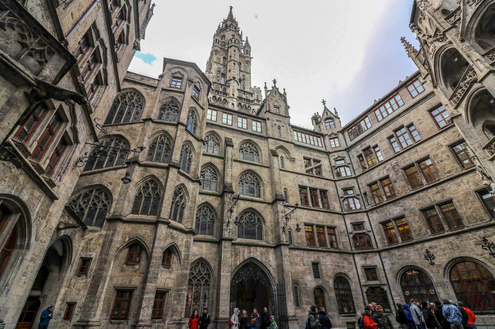 An ornate stone tower and sculpted façades seen from an enclosed courtyard.