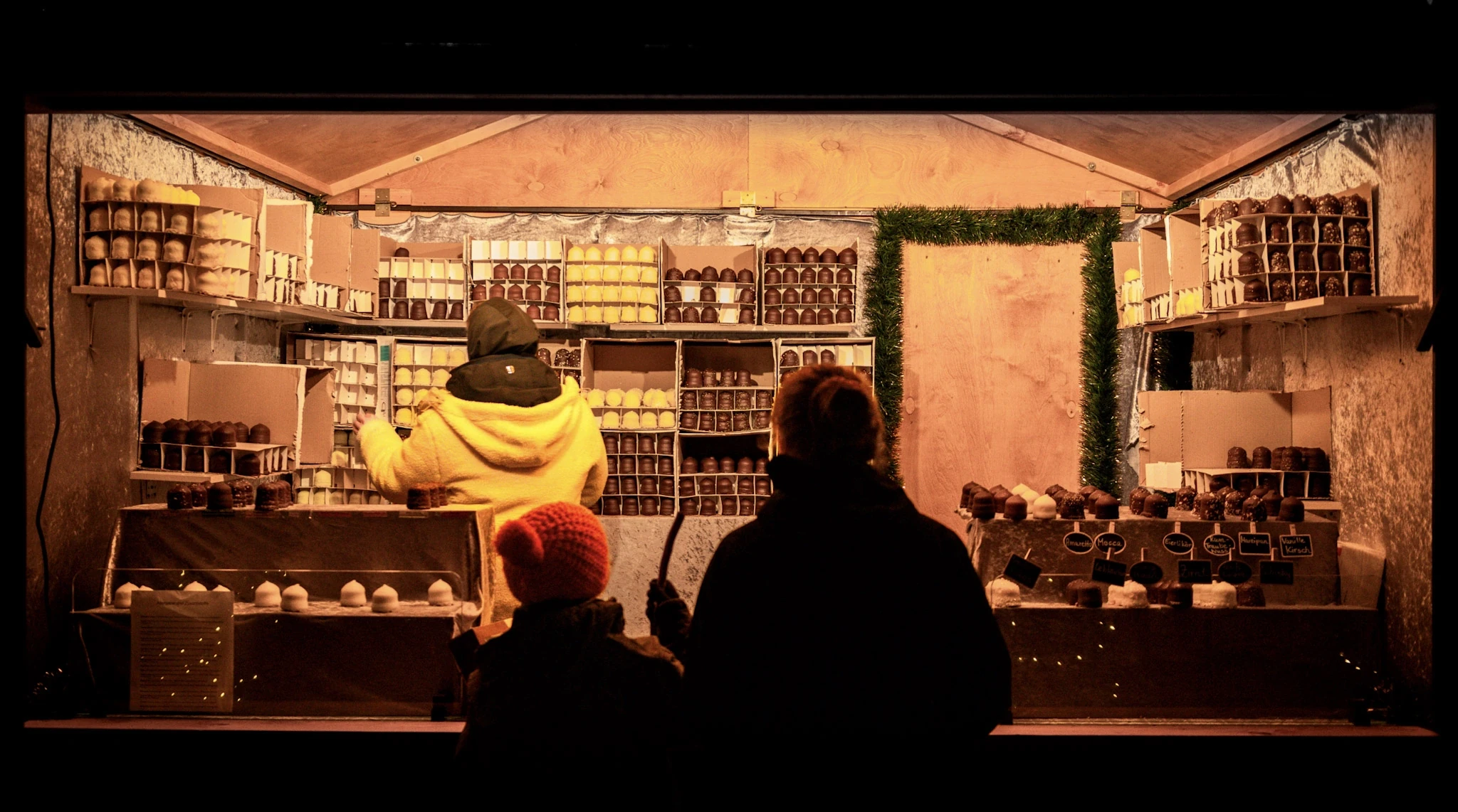 Diners silhouetted against the warm interior of a small restaurant.