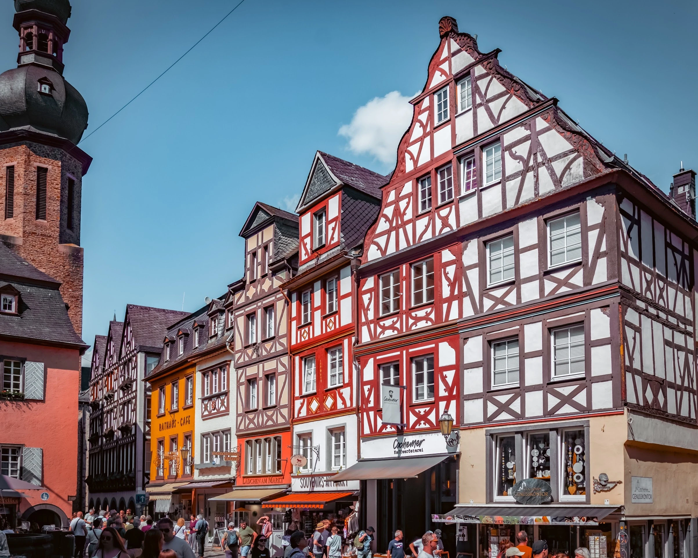 A red timber-framed building among colourful façades in a German old town.