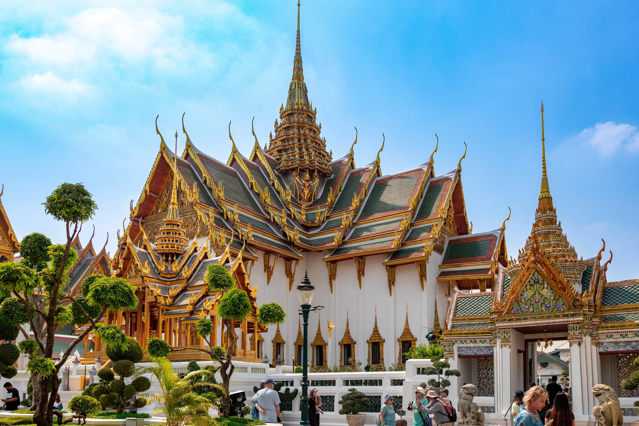 Ornate temple roofs and gilded details rising above a garden.