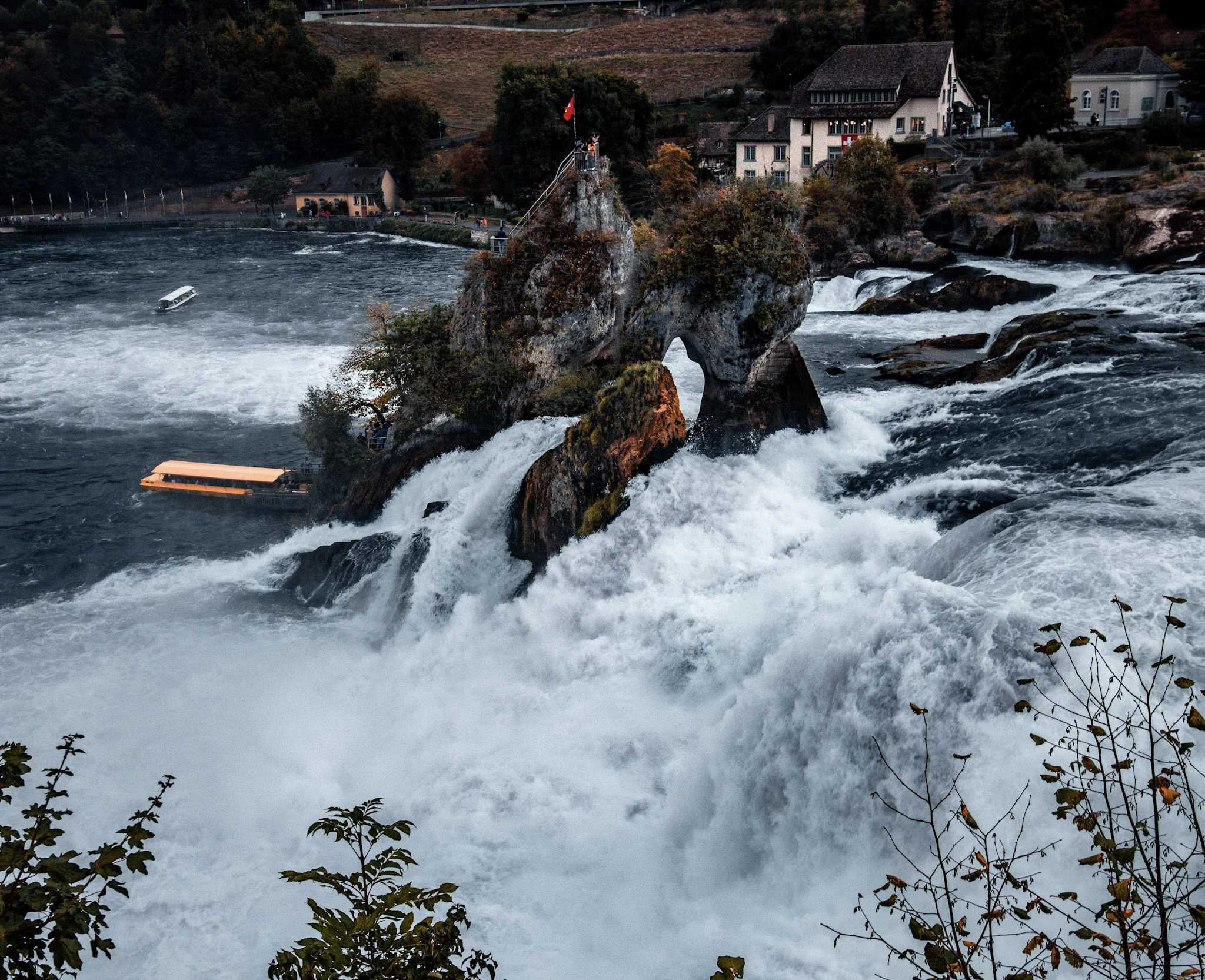 Fast-moving water rushing around jagged rocks in a mountain river.