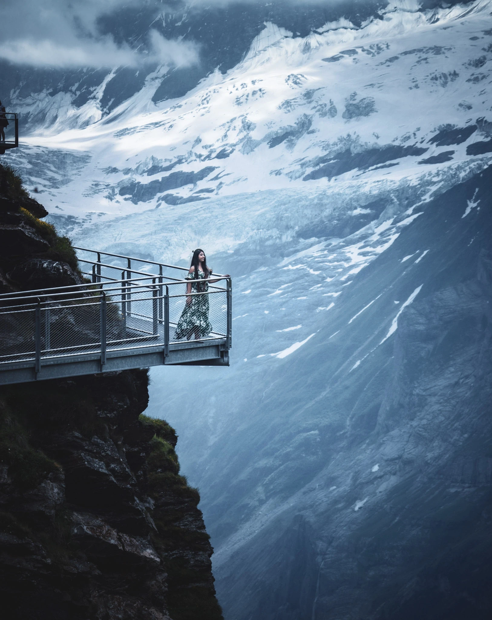 A viewing platform and path cut into a snowy mountain slope.