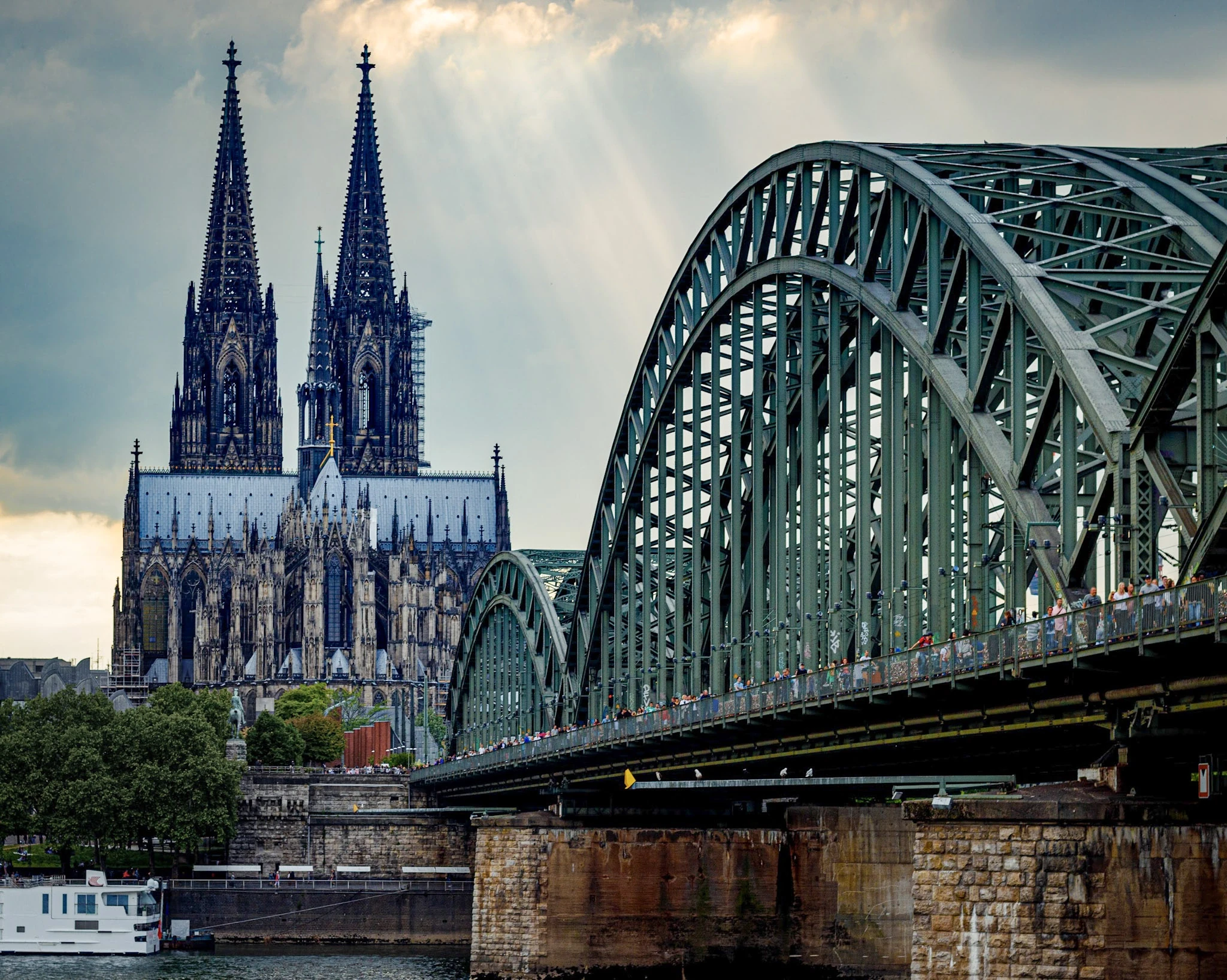 Cologne Cathedral's twin spires beside the arched railway bridge over the Rhine.