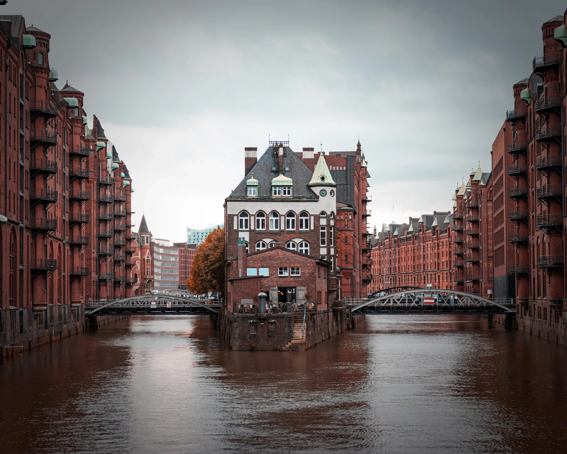 A quiet canal between Hamburg's red-brick warehouse buildings.